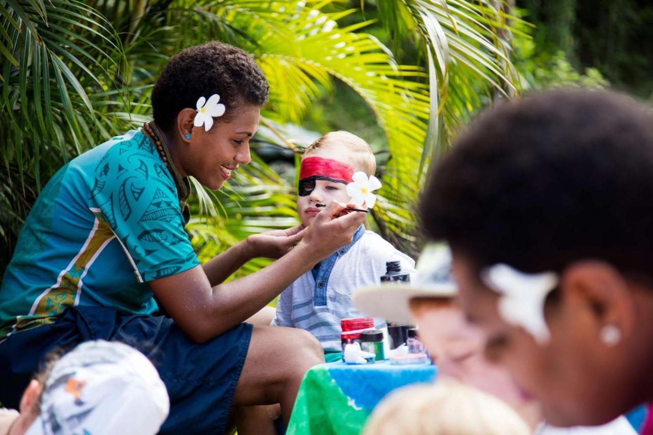 Outrigger Fiji Beach Resort Korotogo Eksteriør bilde A young woman from the Cook Islands applying titi muka to a child's face